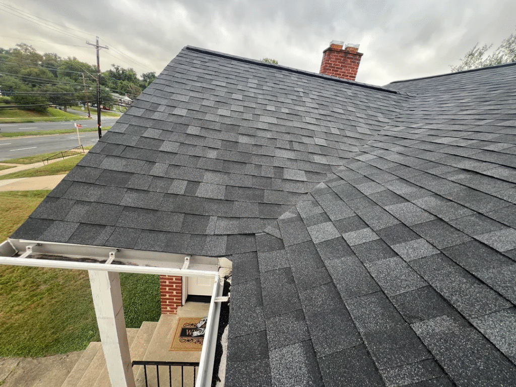 A professionally installed section of dark gray Billings Shingle Roofing by Wegner Roofing & Solar, showing a clean roofline and flashing near a gutter and entryway.