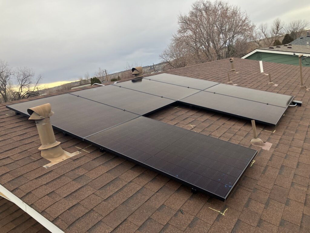 Des Moines Flat Roofing by Wegner Roofing & Solar showing a residential asphalt shingle roof with a professionally installed solar panel array.