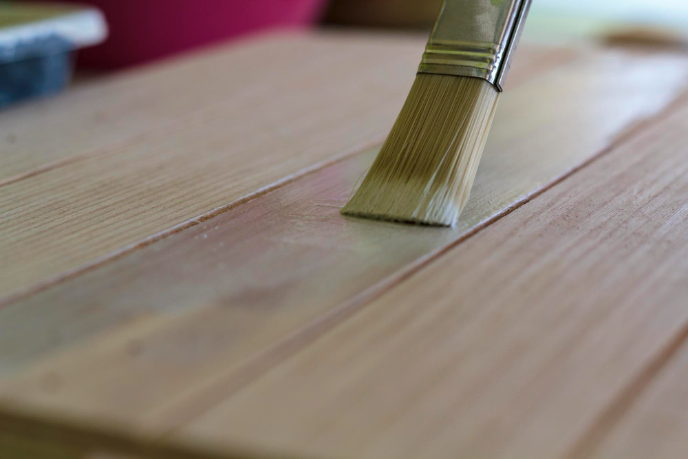 Applying finish coat for Greensboro hardwood color correction and protection.