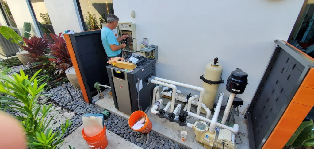 A certified technician from Craft Master Pools and Spas performing a Mooresville Pool Repair on an advanced pool equipment pad, troubleshooting the main control panel.