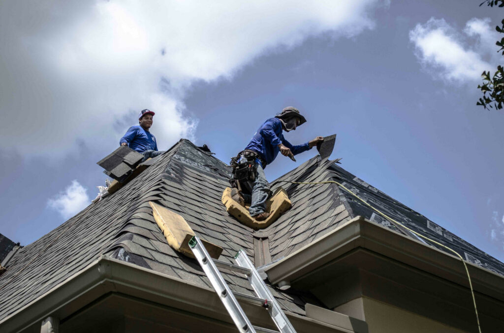 Residential Roofing Services Wrightsville Beach NC by Burish Builders Wilmington. Roofers install dark asphalt shingles.