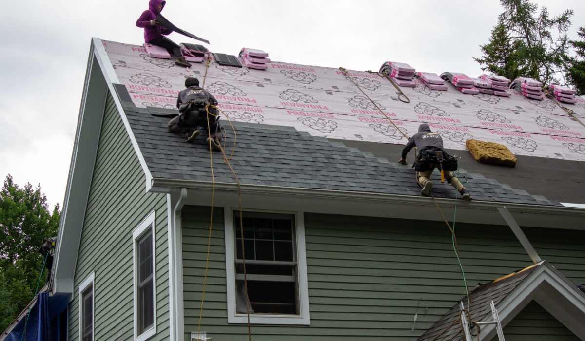 Roofing Installation Franklin NC by Burish Builders Asheville: Professionals install asphalt shingles and underlayment.
