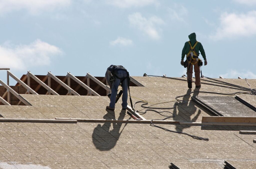 Roofing Installation Franklin NC by Burish Builders Asheville: Crew secures plywood decking on a new home construction.