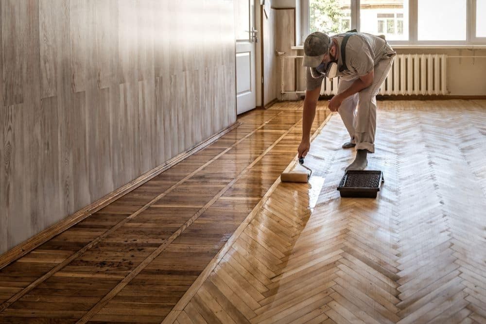 Professional applying Hardwood Floor Polishing & Maintenance Mill Creek WA to a classic herringbone pattern floor.