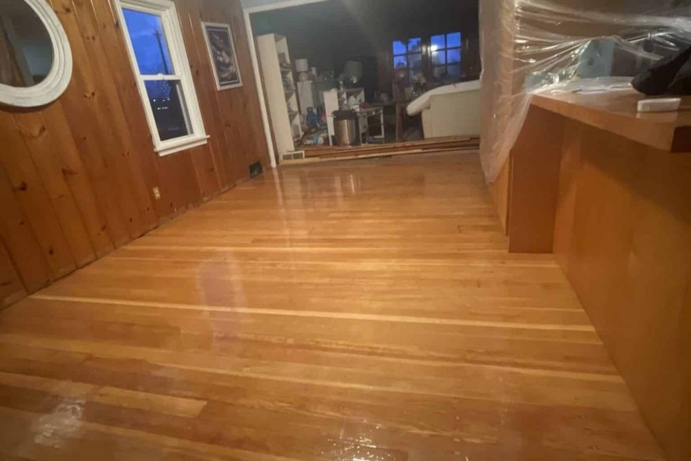 Professional hardwood floor refinishing Mill Creek WA showing a high-gloss finish on restored wood planks.