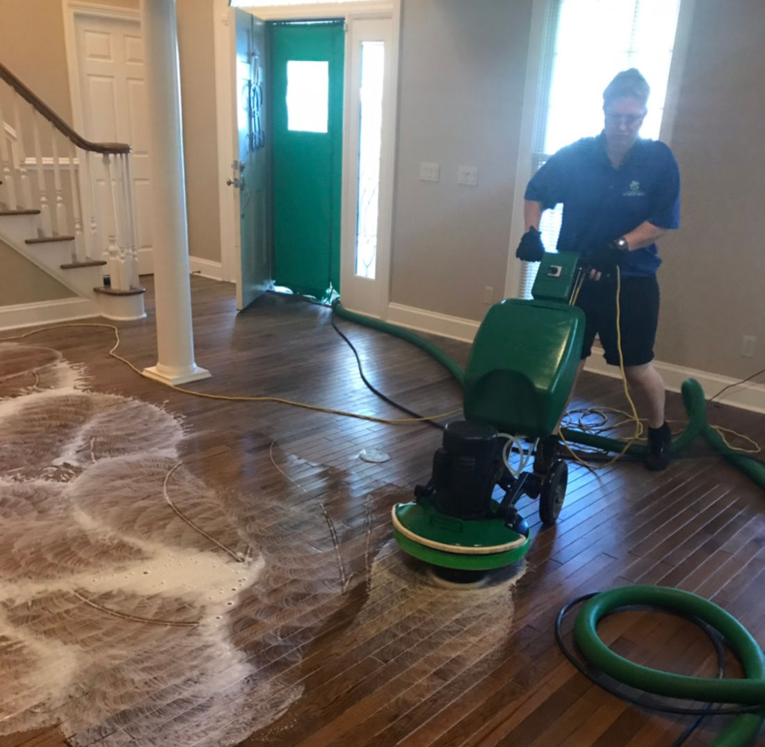 Hardwood Floor Wax Removal Mint Hill NC by Good House Floor Care: specialist using a floor buffer to deep clean wood.