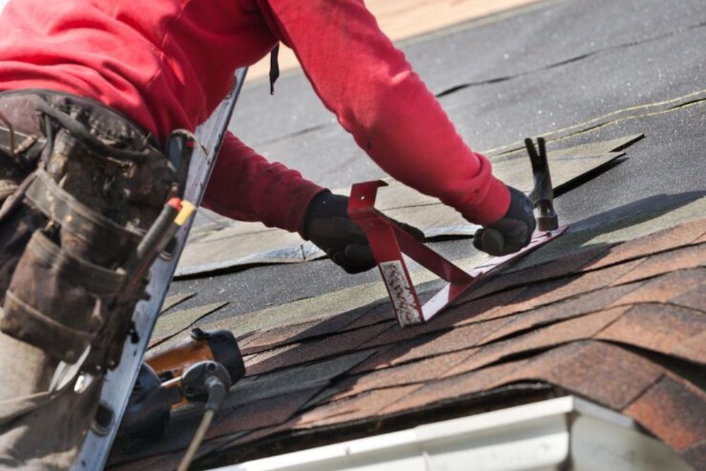 Professional contractor performing Myrtle Creek residential roof repair by installing asphalt shingles.