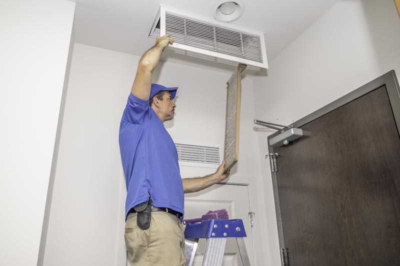 Residential Airduct Cleaning Fort Carson, CO by HP Duct Cleaning: An expert technician replaces a dirty HVAC air filter.