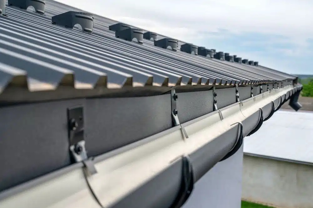 Close-up of a new residential gutter installation on a metal roof in Washington, MN.