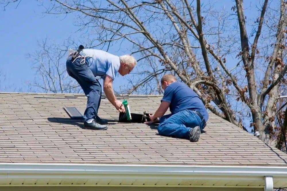 Expert residential roofing contractors Scott MN performing a precision shingle repair and applying sealant.