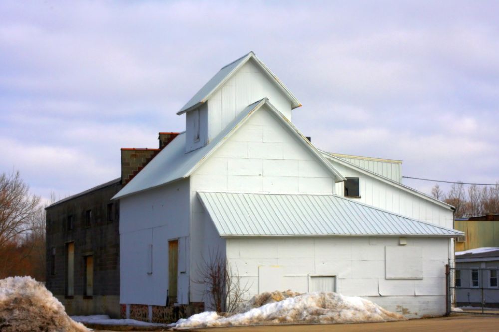 Completed Winston Residential Roof Replacement featuring a durable white standing seam metal roof on a multi-level home.