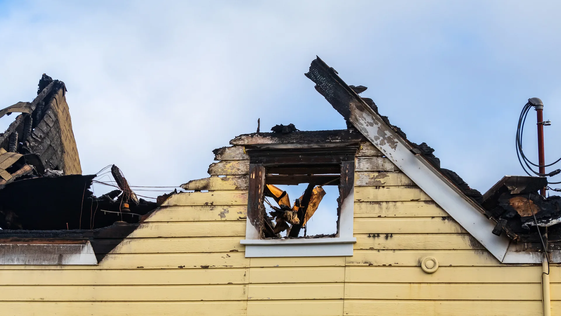 Fire Damage Repair Colorado Springs CO by Premier Carpet Cleaning: Severe structural fire damage to a home's roof and siding.