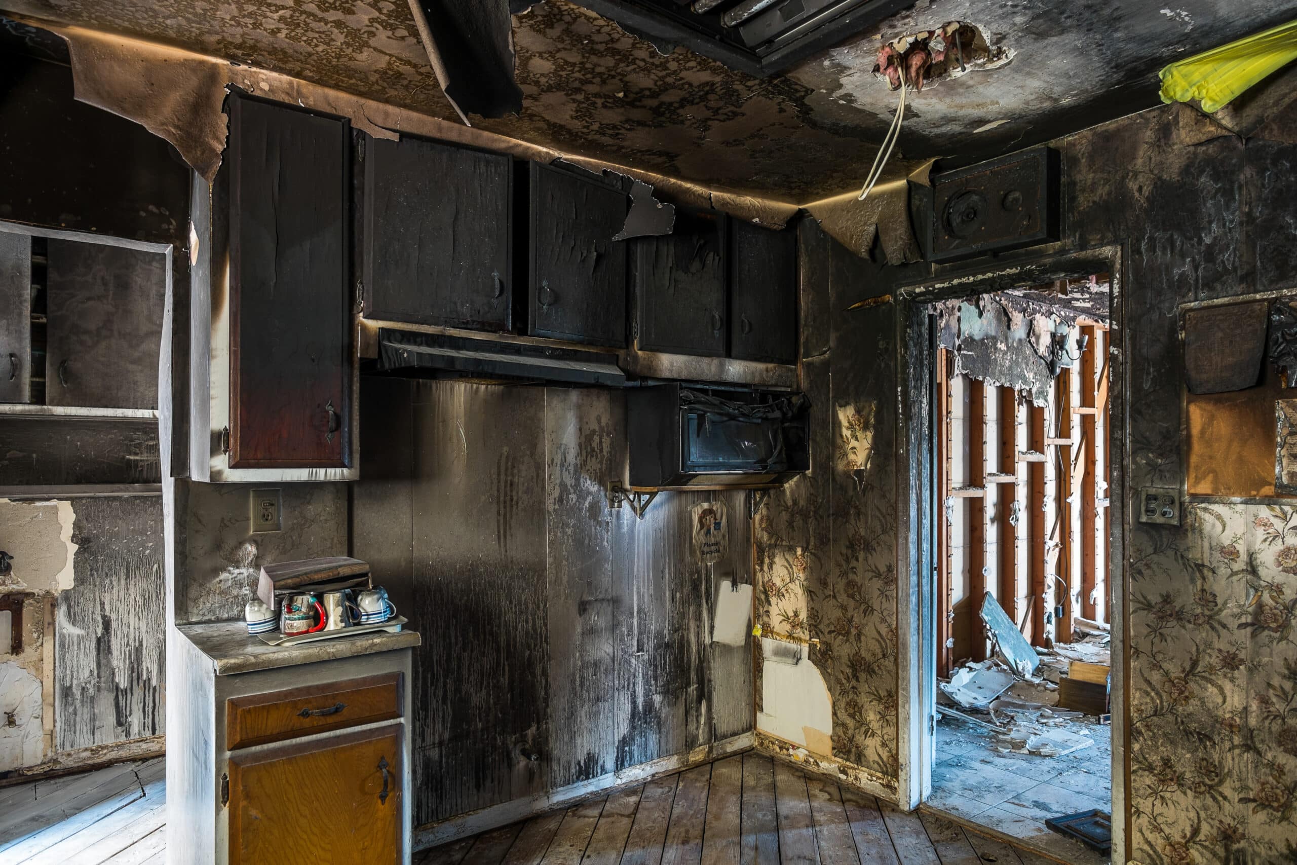 Fire Damage Restoration Colorado Springs CO by Premier Carpet Cleaning: Severely burnt kitchen cabinets and smoke-stained walls.