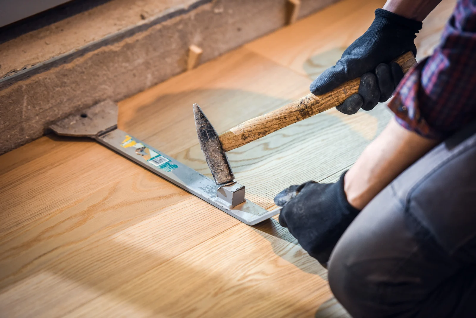 Hardwood Floor Repair Montclair VA by Spotless Carpet Cleaning & Hardwood Floor Care: A technician uses a pull bar and hammer.