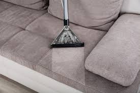 Professional upholstery cleaning Colorado Springs CO by Premier Carpet Cleaning removes deep dirt from a grey fabric sofa.