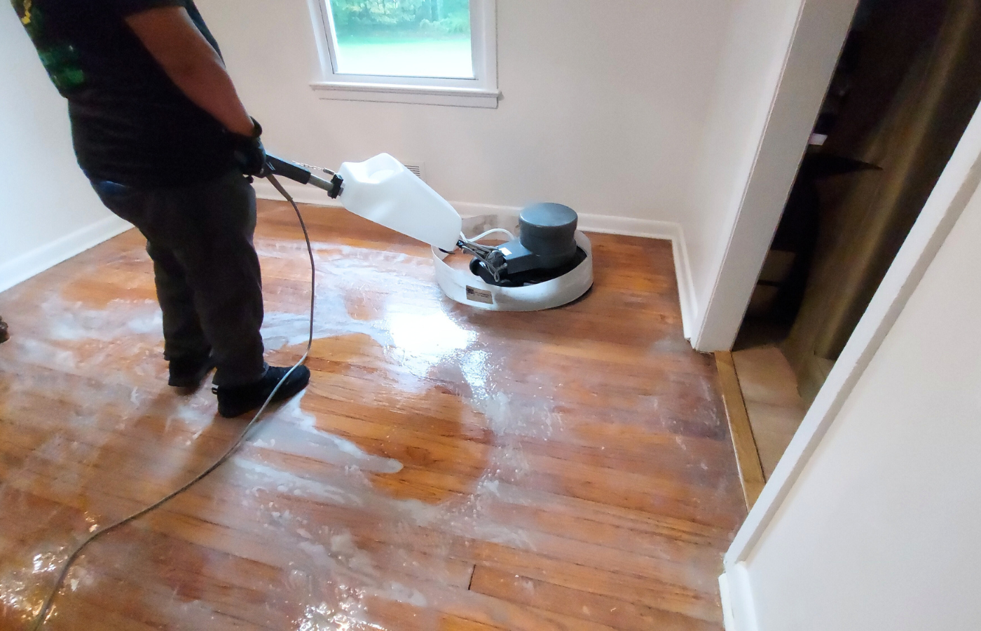 Expert Wood Floor Cleaning Colorado Springs CO by Premier Carpet Cleaning using specialized buffer equipment on oak floors.