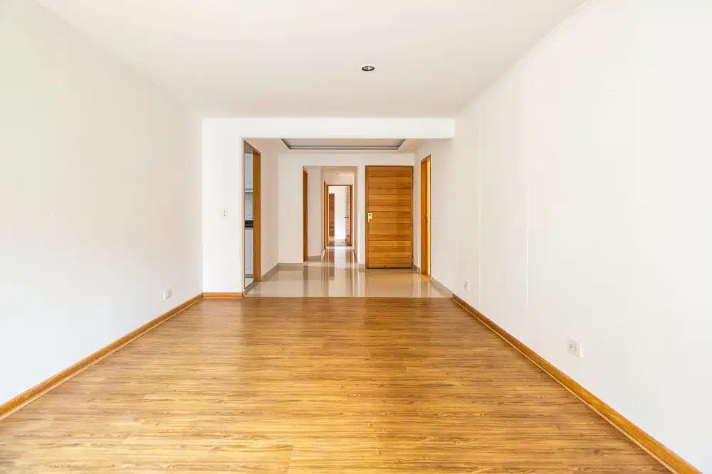 Professional hardwood floor refinishing Kirkland WA showing a restored living space with polished golden oak planks and white walls.