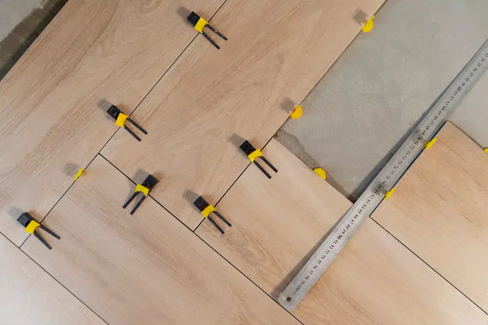 Precision Canton GA hardwood floor installation showing leveling spacers and measurement tools on light oak-style planks.
