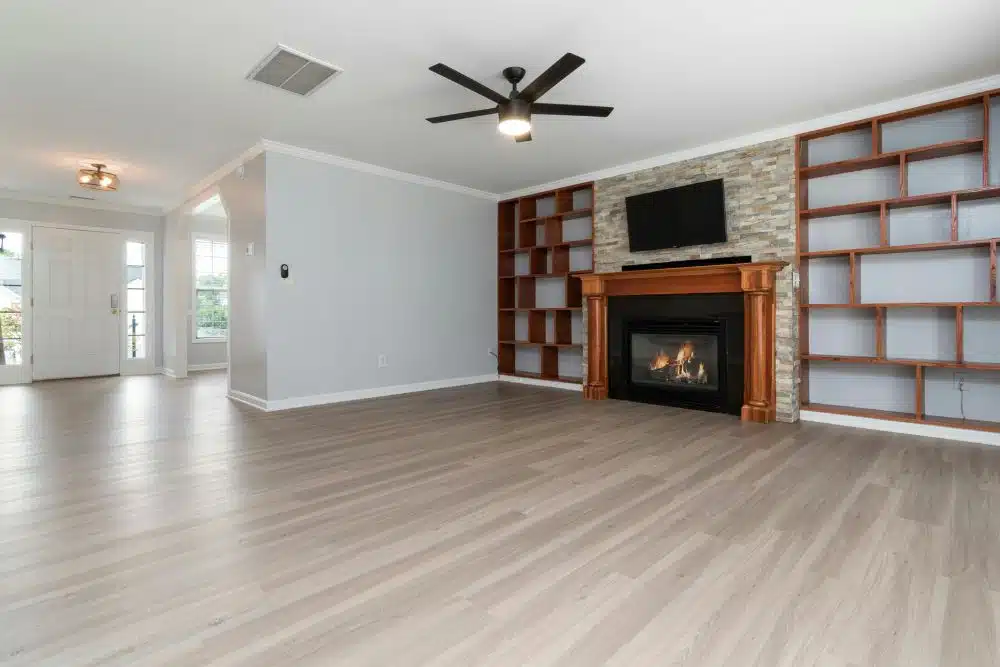 Completed Decatur, GA hardwood floor refinishing project featuring a smooth, light-toned matte finish in a spacious living room with a fireplace.