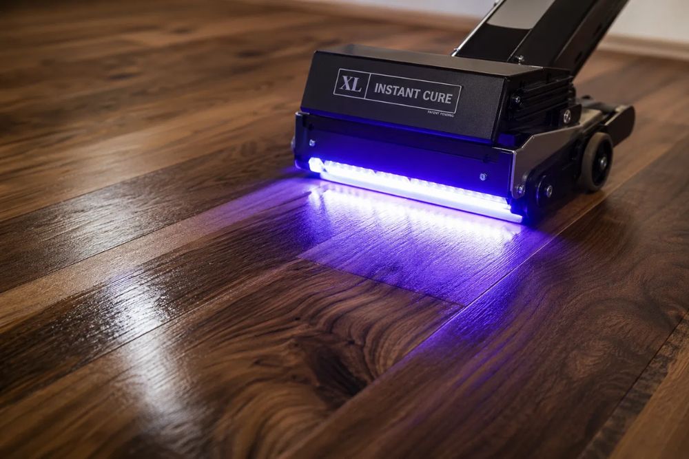 Close-up of hardwood floor Instant UV Curing with a handheld device in Lynnwood WA.
