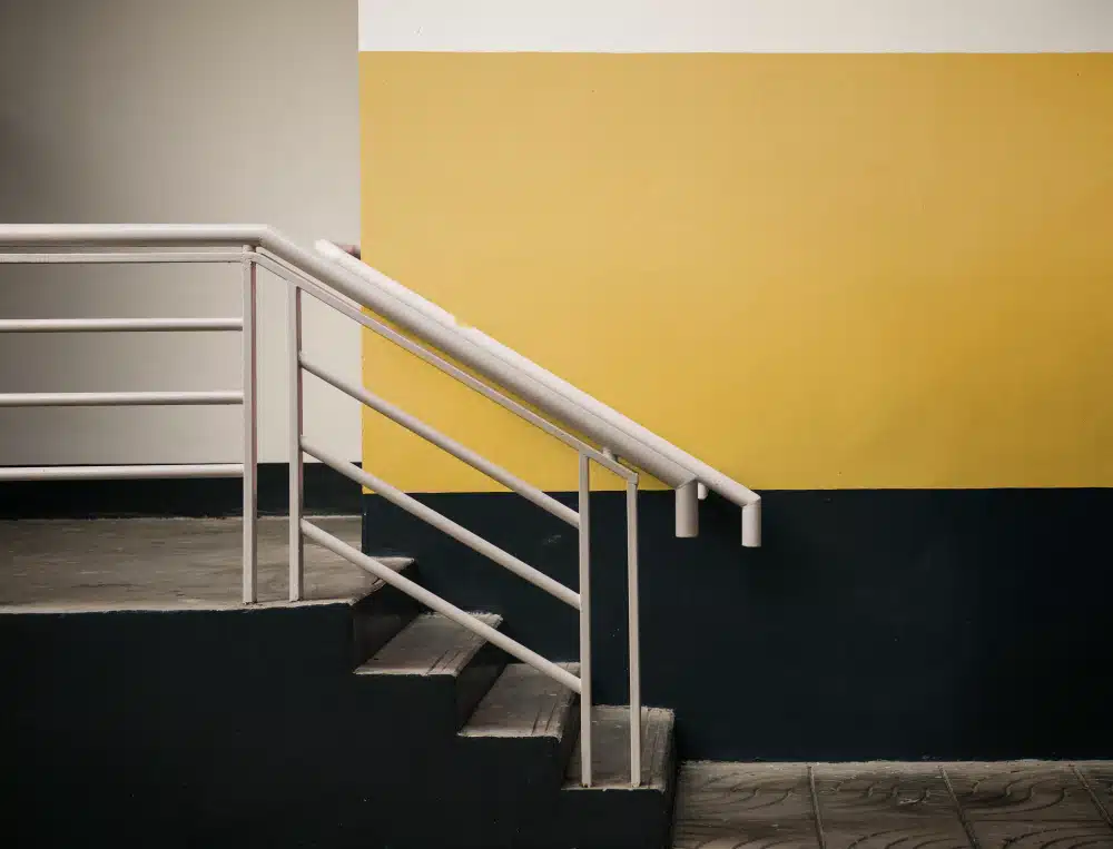 Interior Johns Creek, GA staircase and handrail installation with white railing and colorful wall.