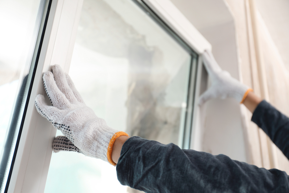 Expert Window Replacement Nashville TN by Wegner Roofing & Solar featuring a professional installing a new white vinyl window.