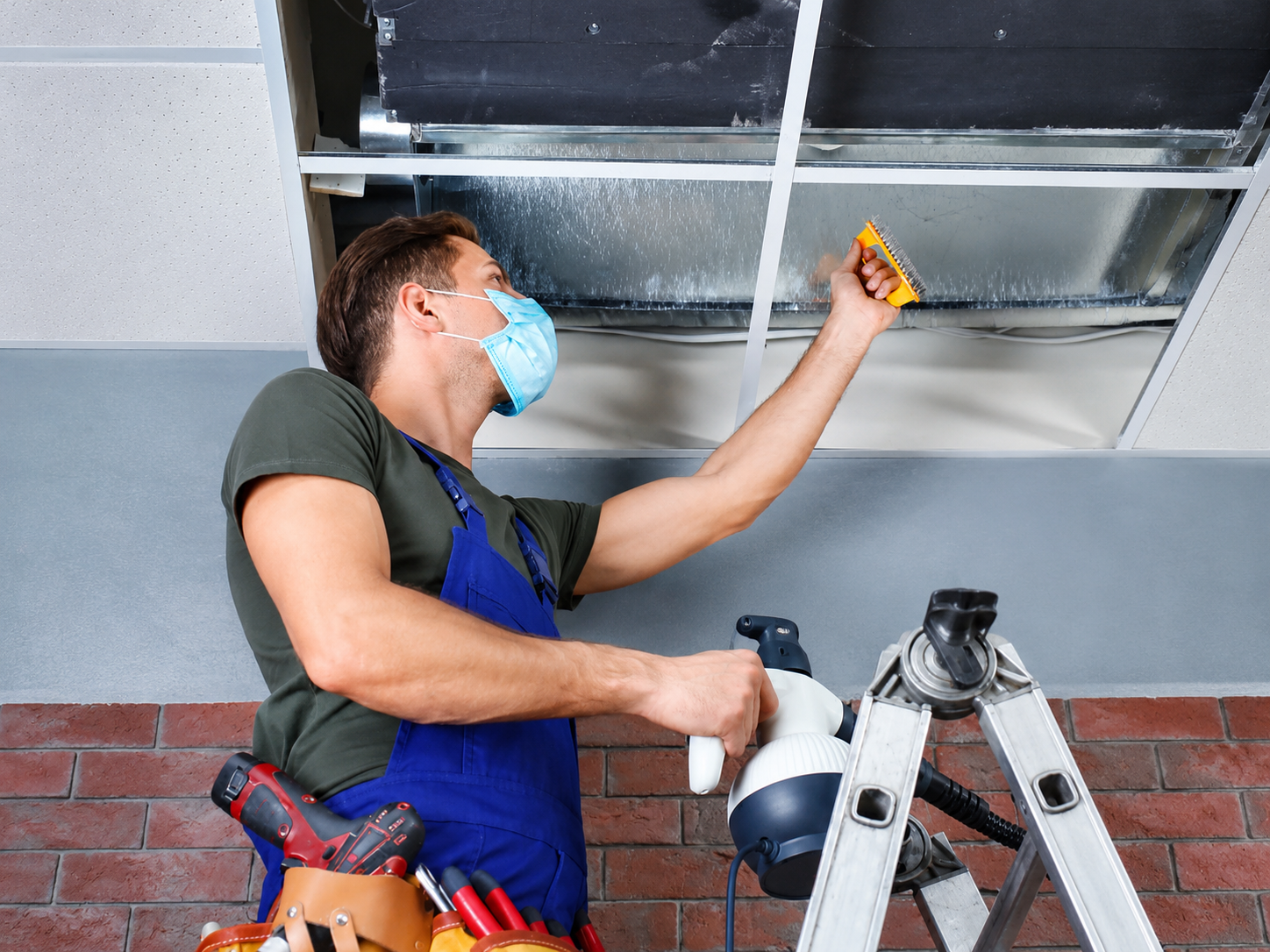 Technician performing Commercial Air Duct Cleaning Fountain CO for HP Duct Cleaning using specialized vacuum and brush.